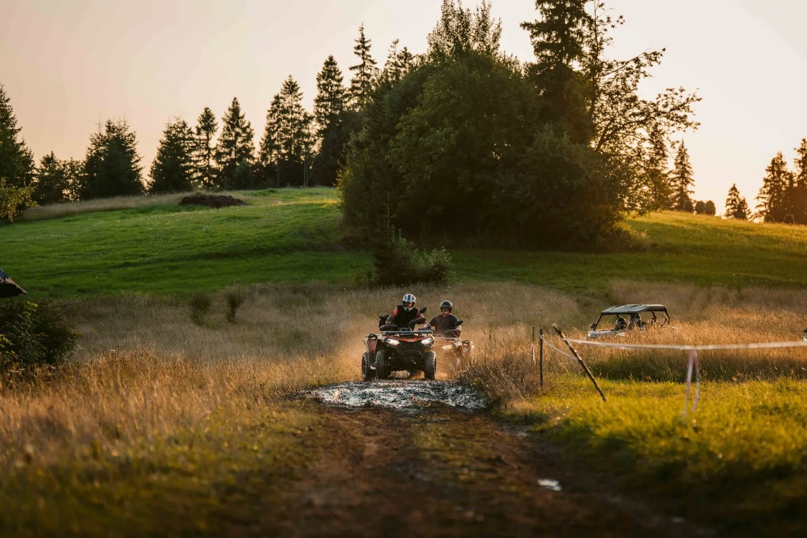 Quad i buggy ZFORCE pokonujące błotną kałużę o zachodzie słońca